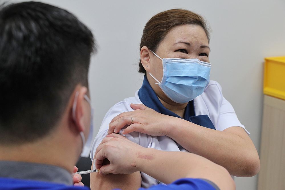 Healthcare worker Sarah Lim receives her Covid-19 vaccine at the National Centre for Infectious Diseases (NCID) in Singapore December 30, 2020. u00e2u20acu201d Ministry of Communications and Information handout via Reuters