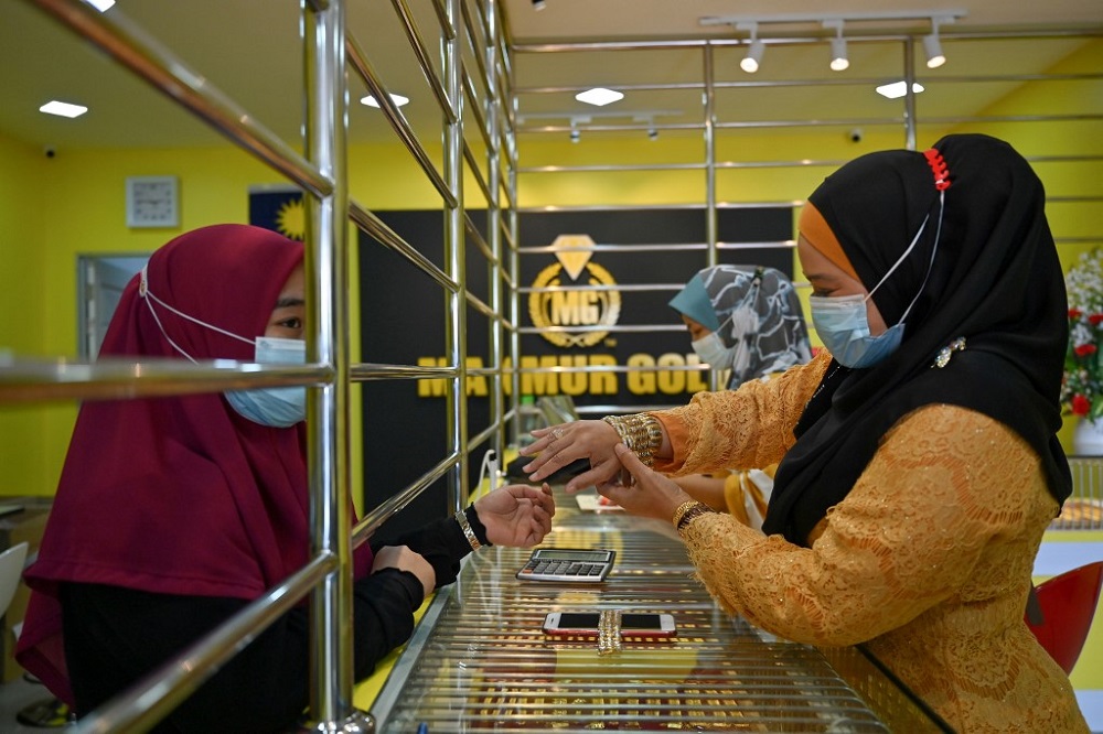 This picture taken shows a customer trying on a bracelet at the Makmur Gold shop in Kota Baru November 8, 2020. u00e2u20acu2022 AFP pic