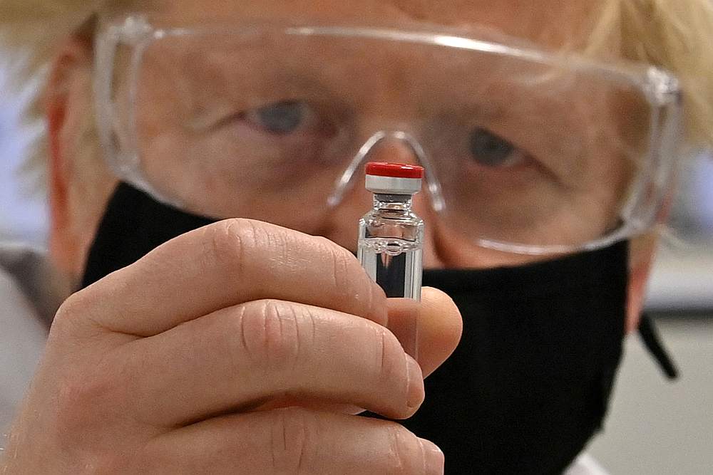 Britain's Prime Minister Boris Johnson poses for a photograph with a vial of the AstraZeneca/Oxford University Covid-19 candidate vaccine, known as AZD1222, in Wrexham, Wales, Britain November 30, 2020. u00e2u20acu201d Pool pic via Reuters