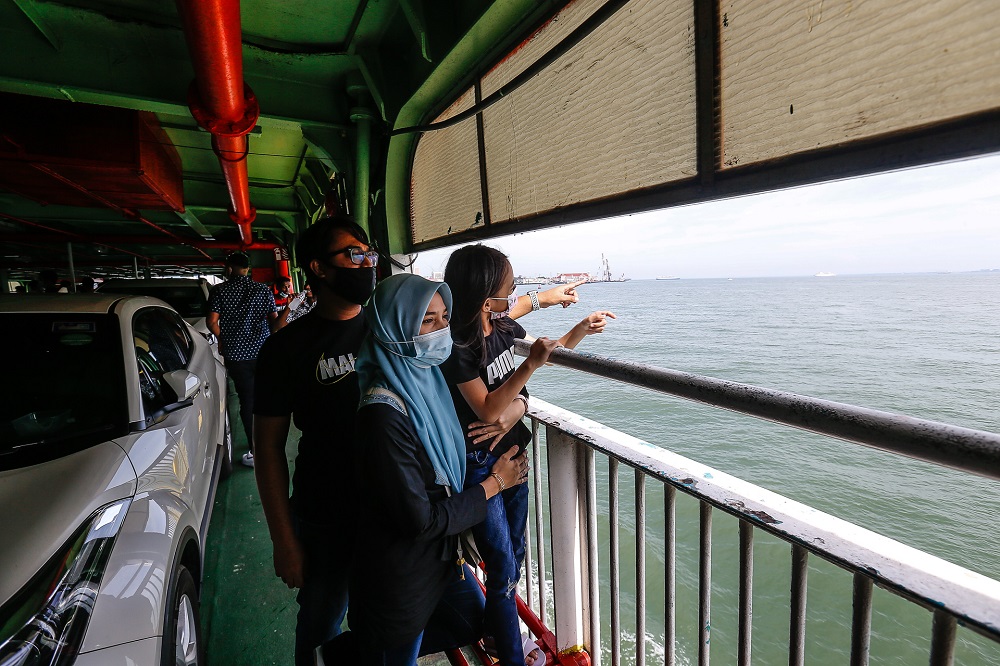 A family enjoying the view while boarding the ferry service for the last time here at Pengkalan Raja Tun Uda Ferry Terminal on December 31, 2020. u00e2u20acu2022 Picture by Sayuti Zainudin