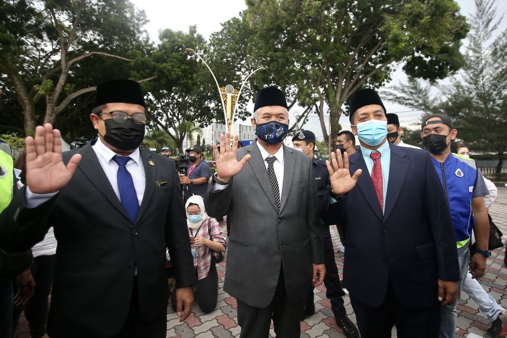 Perak PAS assemblymen (from left) Mohd Akmal Kamaruddin, Razman Zakaria and Khalil Yahaya wave at reporters at Istana Kinta, Ipoh December 9, 2020. u00e2u20acu201d Picture by Farhan Najib