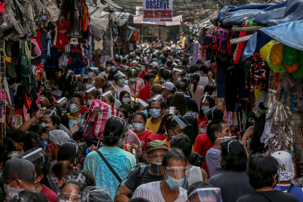People wearing face shields and masks amid the Covid-19 coronavirus pandemic visit a popular shopping market hours before Christmas eve in Manila December 24, 2020. u00e2u20acu201d AFP pic 