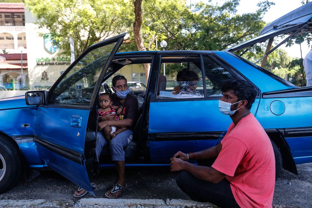 S. Ganesh, his wife Parameswari, and three young children have had to live out of his car after their house on Carnarvon Street caught fire in April. u00e2u20acu201d Picture by Sayuti Zainudin
