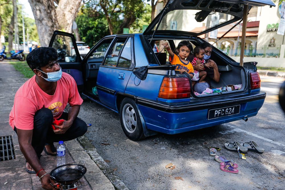 S. Ganesh, his wife Parameswari, and three young children have had to live out of his car after their house on Carnarvon Street caught fire in April. u00e2u20acu201d Picture by Sayuti Zainudin