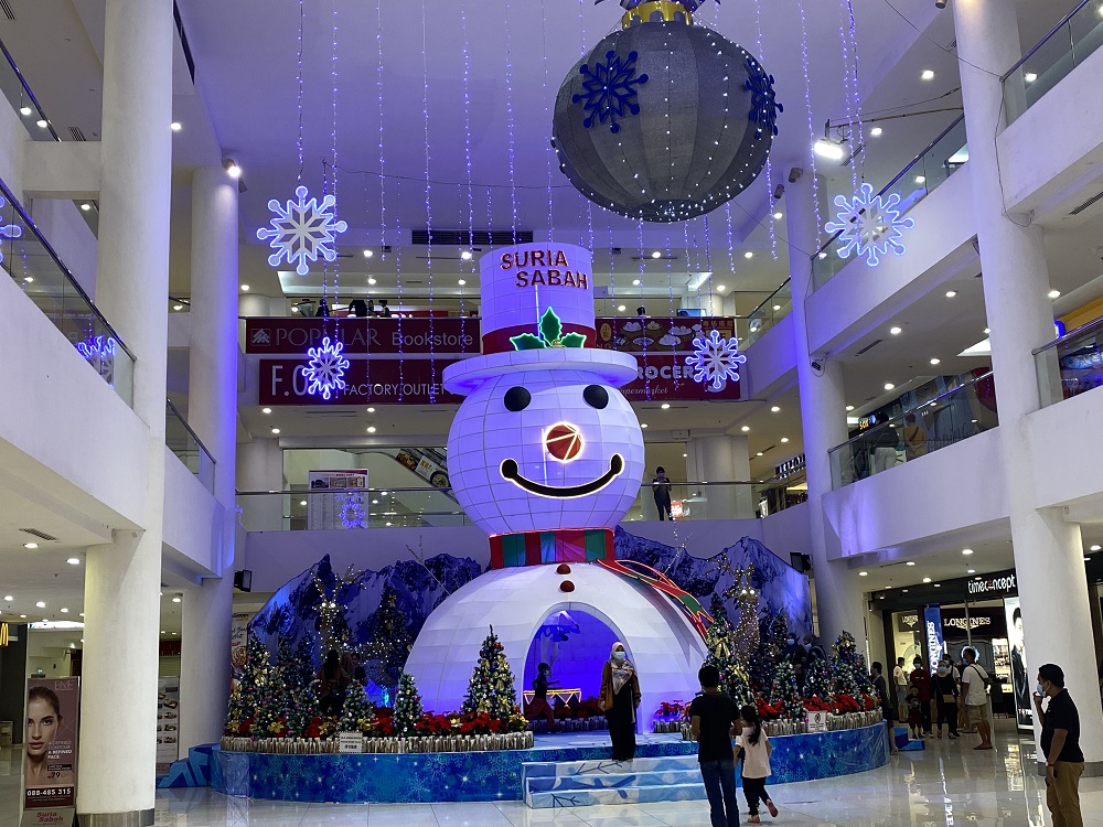 Visitors pose for pictures with the Christmas displays at a shopping mall in Kota Kinabalu. ― Picture by Julia Chan