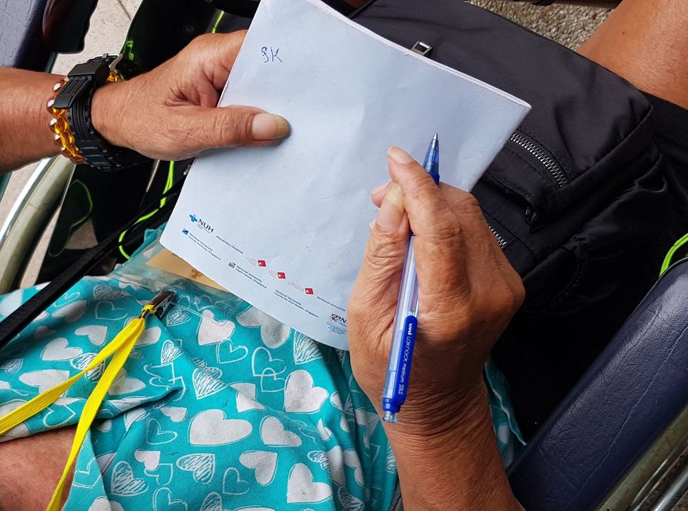 Uncle Leong writing the author’s name down. The author says he captured the moment to remind himself to do more good and help more people.