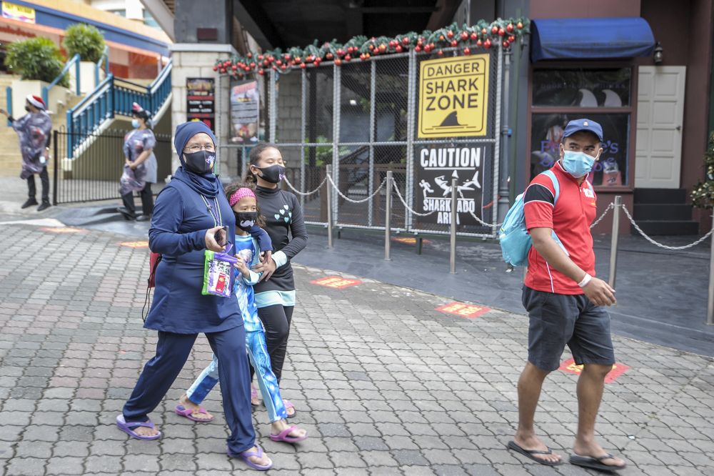 Banker Rozy Mohd Zin is seen with her children and husband at the Sunway Lagoon water park in Subang Jaya December 19, 2020. — Picture by Shafwan Zaidon