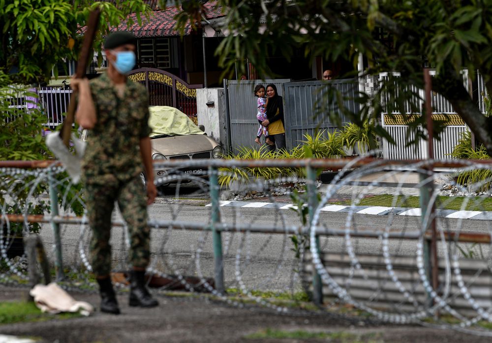 Residents looking at military personnel installing barbed-wire fencing around Taman Meru 2C, Ipoh, November 19, 2020. u00e2u20acu201d Bernama pic