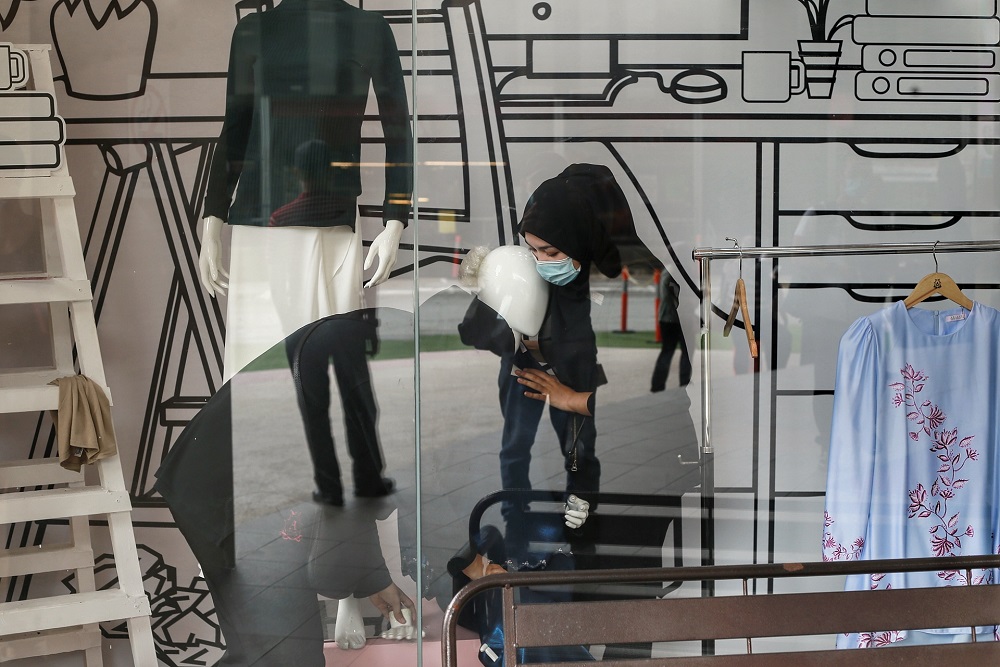 Sales reps dress mannequins with festive Raya outfits at Jakel Mall in Kuala Lumpur May 4, 2020. u00e2u20acu201d Picture by Ahmad Zamzahuri