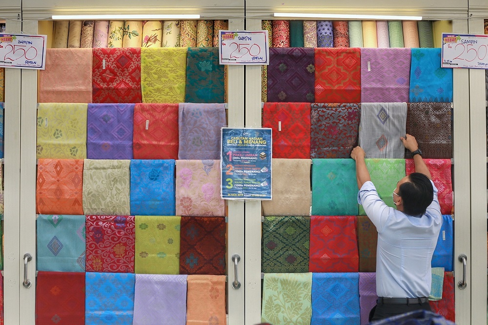 A salesperson arranges clothing at Jakel Mall ahead of the Hari Raya celebrations in Kuala Lumpur May 4, 2020. u00e2u20acu201d Picture by Ahmad Zamzahuri