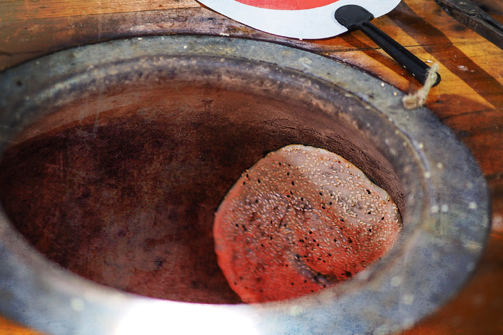 How 'guōkuī' is traditionally cooked – over charcoal inside a clay oven.