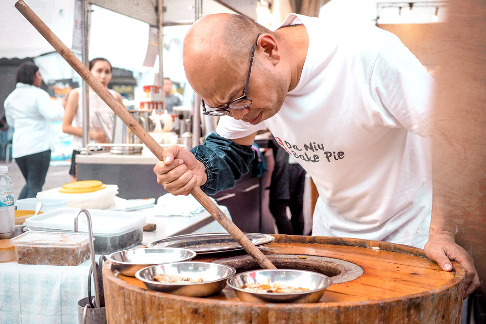 Lim making sure his pies are baked till crispy.