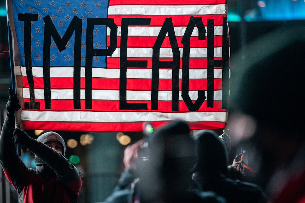 People wearing protective masks hold a US flag at the Barclays Center during the u00e2u20acu02dcGet him out! defend democracyu00e2u20acu2122 rally, a day after supporters of US President Donald Trump stormed the Capitol, New York January 7, 2021. u00e2u20acu201d Reuters pic