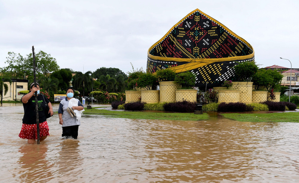 Residents from Pekan Donggongon Penampang wade in flood waters caused by continuous heavy rainfall, January 17, 2021. u00e2u20acu201d Bernama pic