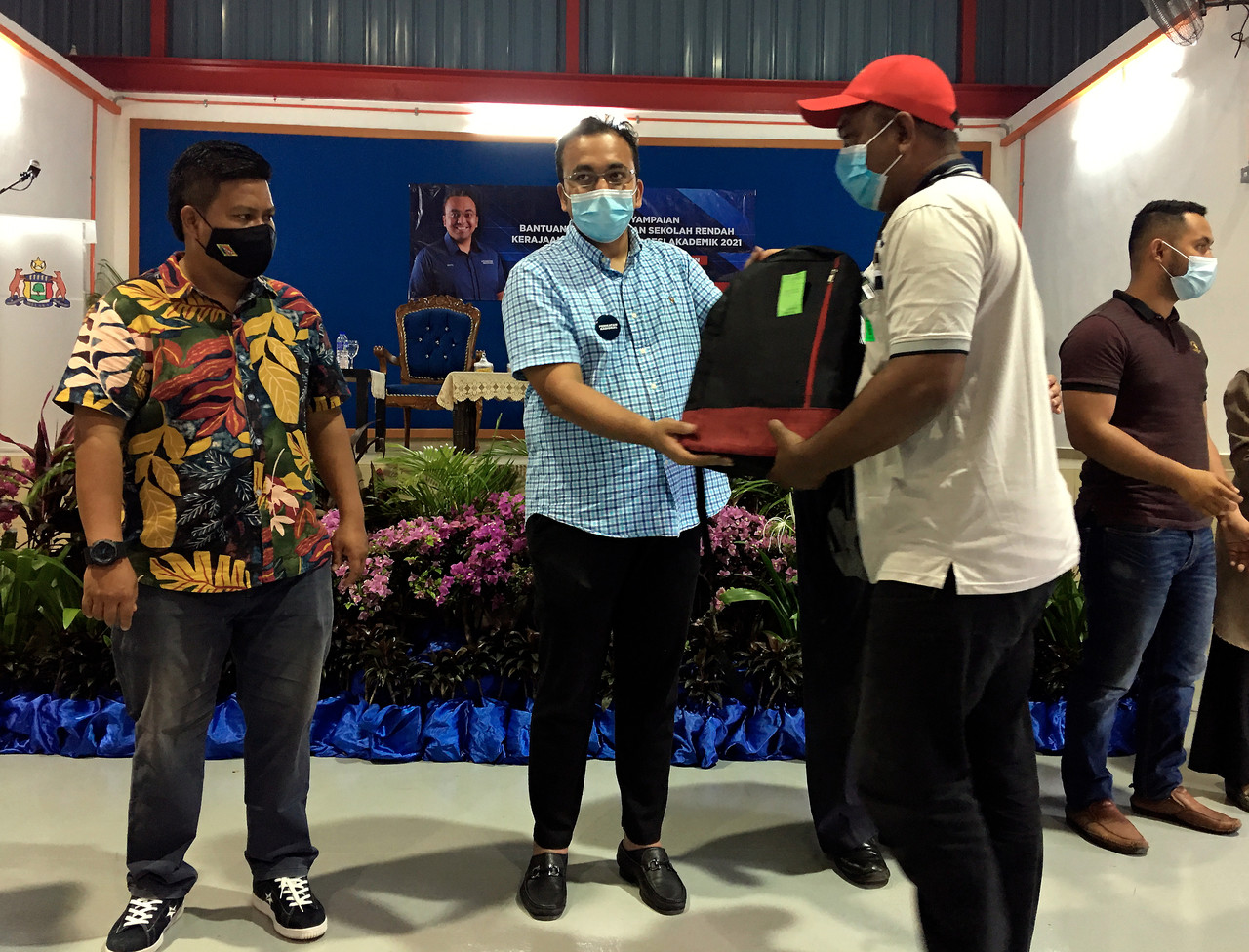 Pengerusi Jawatankuasa Pertubuhan Bukan Kerajaan (NGO), Pembangunan Belia dan Sukan Melaka Datuk Mohd Rafiq Naizamohideen (dua, kiri) menyampaikan sumbangan kepada salah seorang penerima pada majlis penyampaian bantuan persekolahan peringkat Dewan Undanga