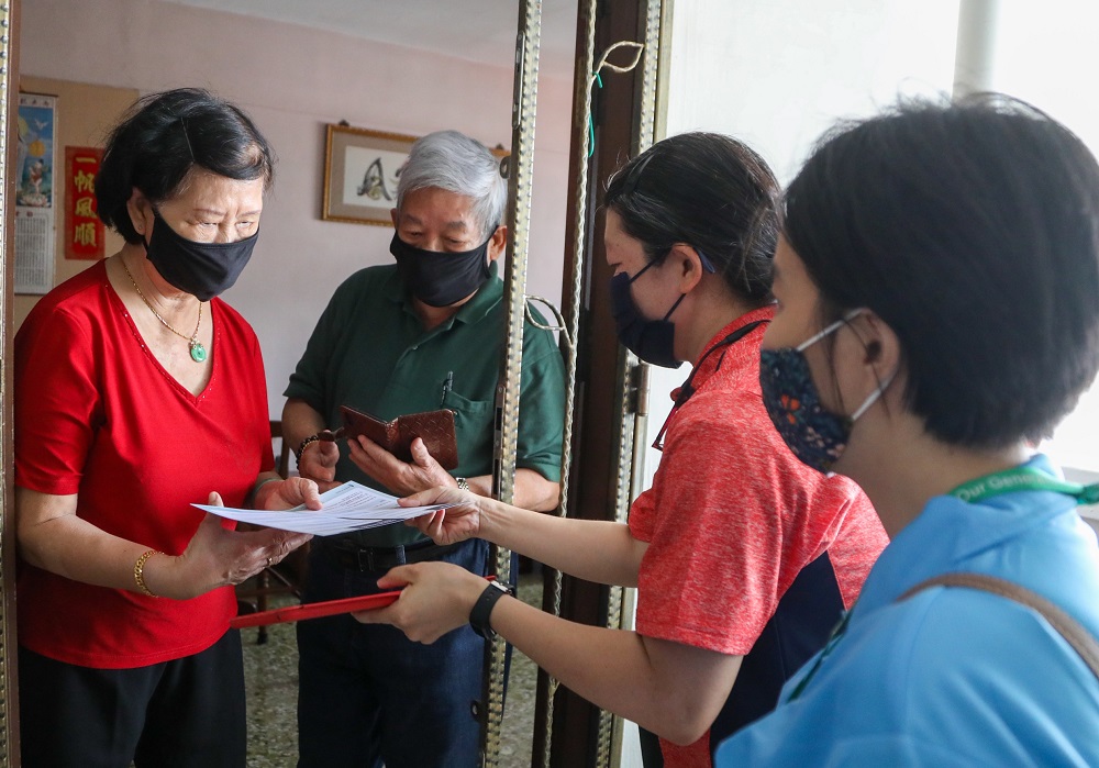 Volunteers doing house visits in Tanjong Pagar to inform senior residents on the national voluntary vaccination programme and to encourage them to get inoculated. — TODAY pic