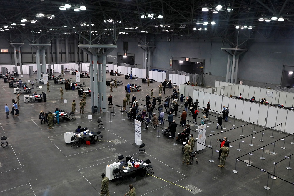 People line up as health care workers and military personnel work to distribute doses of the coronavirus disease vaccine at the New York State Covid-19 vaccination site at the Jacob K. Javits Convention Centre January 13, 2021. u00e2u20acu201d Reuters pic