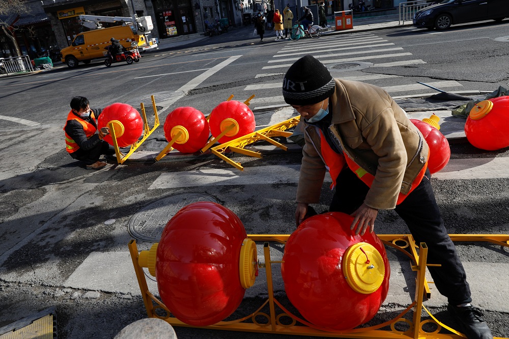 Workers wearing face masks assemble street lights in the shape of Chinese lanterns ahead of the Chinese Lunar New Year holiday, amidst the outbreak of the coronavirus disease, in Beijing January 26, 2021. — Reuters pic