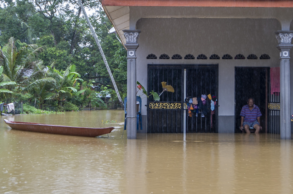 A man is seen sitting inside his house that partially submerged in floodwaters at Kampung Lebak Seberang in Temerloh on January 9, 2021. u00e2u20acu201d Picture by Shafwan Zaidonn