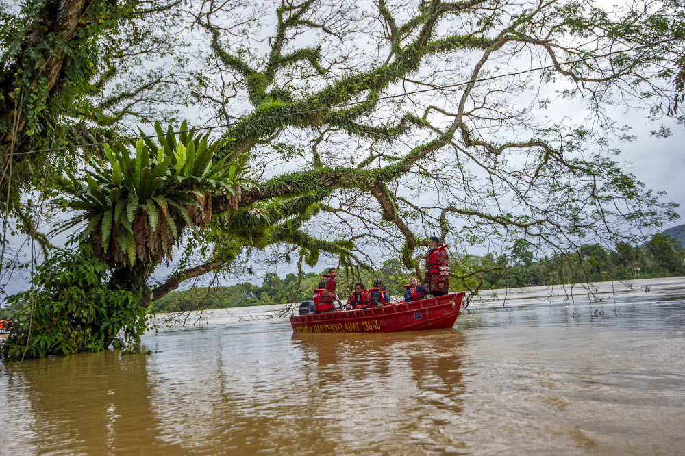 Search and rescue boat passes by submerged houses during flooding at Kampung Chenor, Maran in Pahang January 10, 2021. u00e2u20acu201d Picture by Shafwan Zaidon