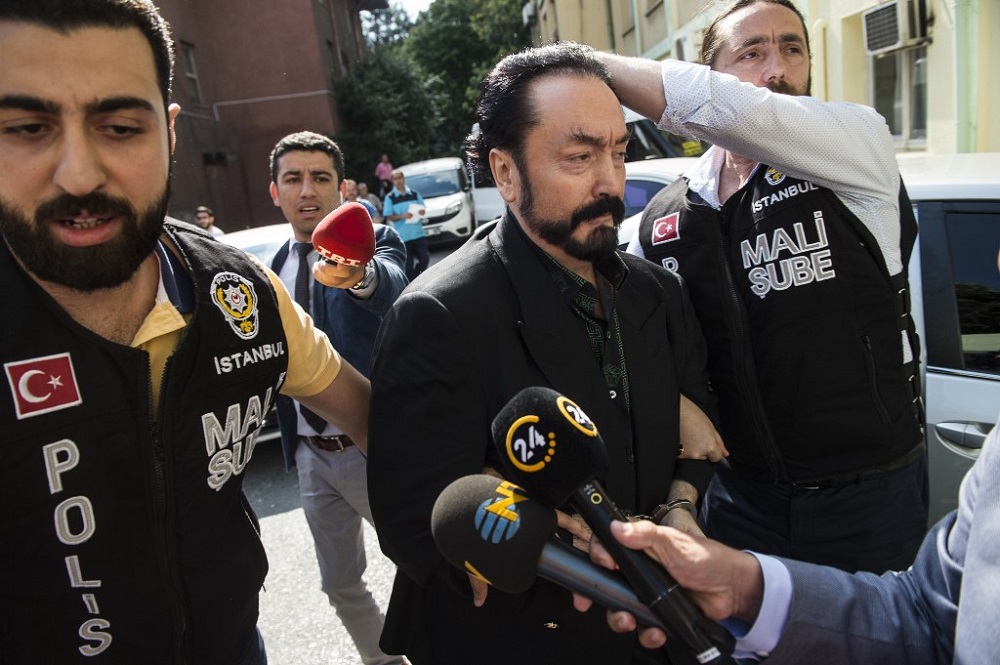 Turkish police officers escort televangelist and leader of a sect, Adnan Oktar (centre), as he is arrested on fraud charges, in Istanbul July 11, 2018. u00e2u20acu201d AFP pic