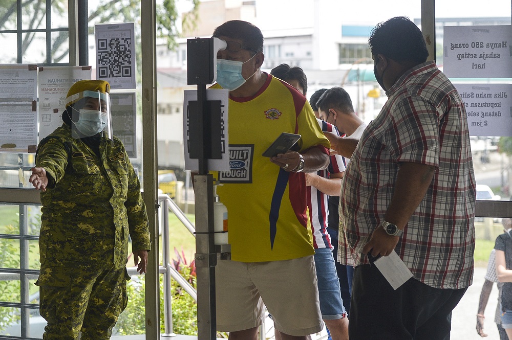 Members of the public check their temperatures before entering a Covid-19 screening area in Petaling Jaya January 18, 2021. u00e2u20acu201d  Picture by Miera Zulyana