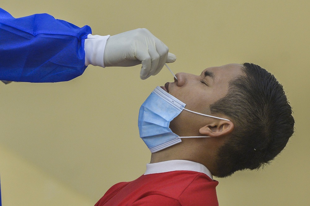 A health worker collects a swab sample from a man to test for Covid-19 in Petaling Jaya January 18, 2021. u00e2u20acu201d  Picture by Miera Zulyana