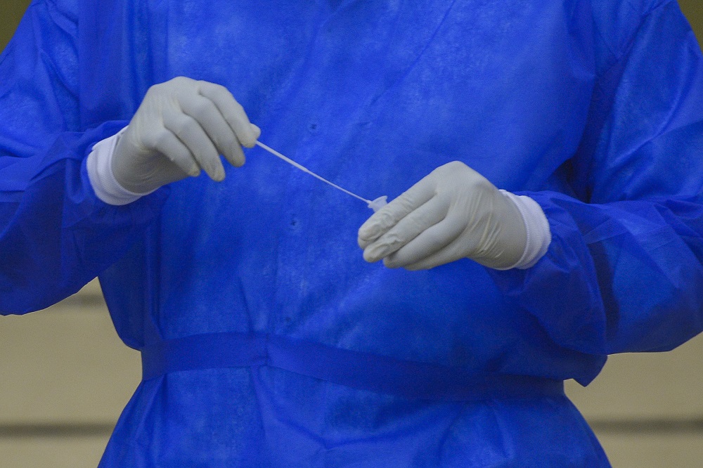 A health worker in protective suit collects swab samples to test for Covid-19 in Petaling Jaya January 18, 2021. u00e2u20acu201d  Picture by Miera Zulyana