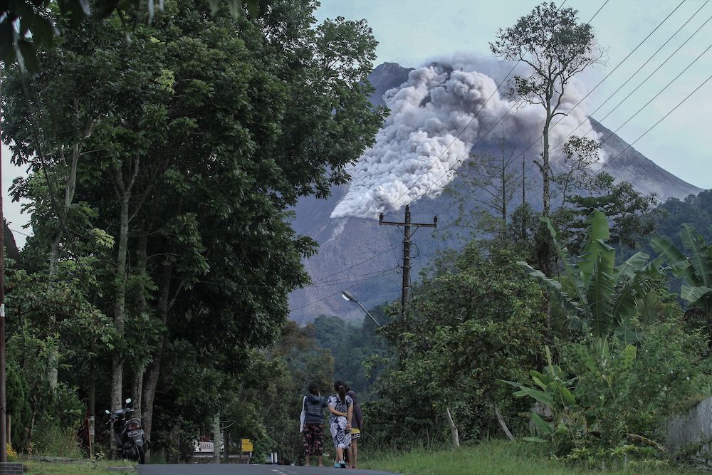 Locals walk on a road as Mount Merapi volcano spews hot ash in Kaliurang, Sleman, Yogyakarta, Indonesia, January 27, 2021. u00e2u20acu201d Photo by Antara Foto via Reuters