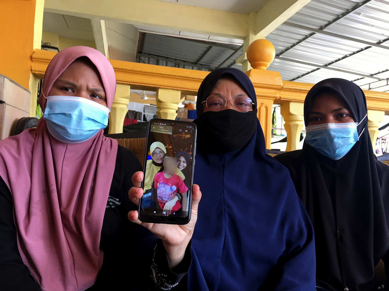 Norlida Abu Hassan, 50 (tengah) menunjukkan gambar anak angkatnya ketika ditemui di Batu Berendam hari ini. u00e2u20acu201d Foto Bernama