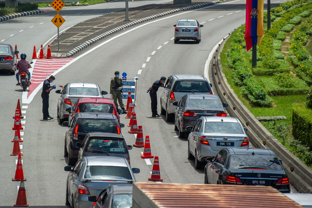 Police officers conducting checks at a roadblock in Jalan Kuching, Kuala Lumpur January 31, 2021. u00e2u20acu201d Picture by Shafwan Zaidon 