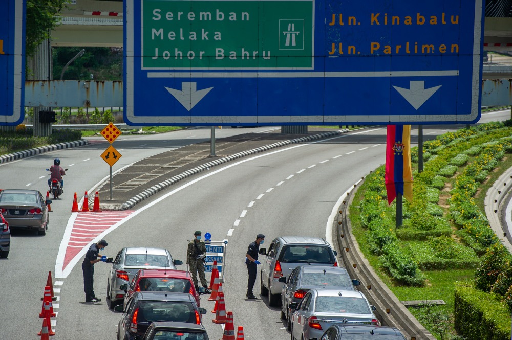 Police officers conducting checks at a roadblock in Jalan Kuching, Kuala Lumpur January 31, 2021. u00e2u20acu201d Picture by Shafwan Zaidon 