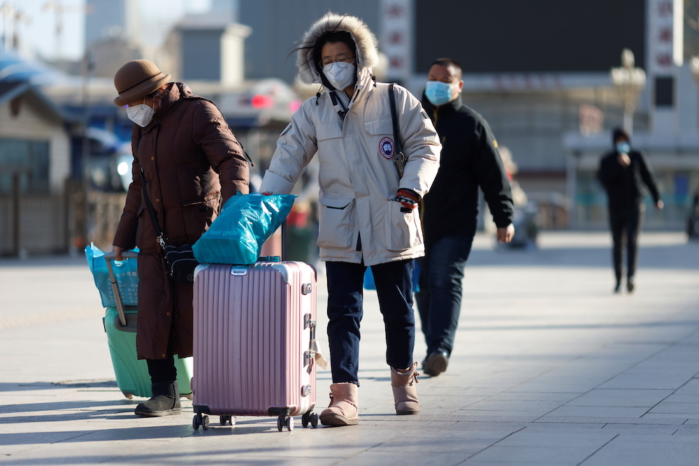 Travellers wearing face masks walk outside a railway station as the Spring Festival travel season begins ahead of the Chinese Lunar New Year, in Beijing January 28, 2021. u00e2u20acu201d Reuters pic 