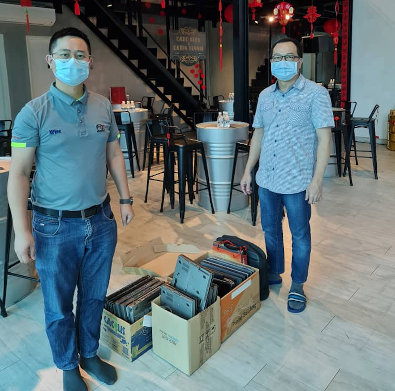 Entrepreneur Datuk Alby Chong (right) hands over the received laptops to a representative of the computer repairer to be refurbished before renting it out. u00e2u20acu201d Picture courtesy of Datuk Alby Chong 