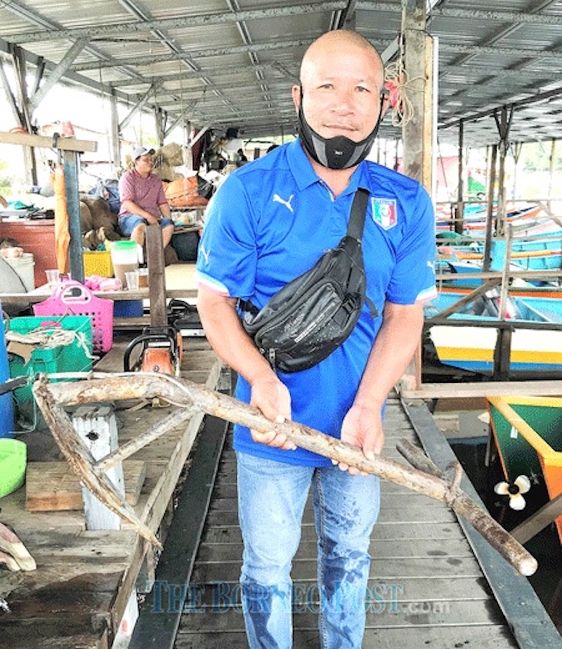 A fisherman shows a home-made anchor. — Borneo Post Online pic