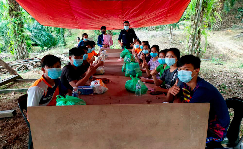 Pelajar Kampung Gana, Ranau menggunakan meja dan khemah yang disediakan oleh PDRM bagi memudahkan mereka mengikuti Kaedah Pembelajaran dan Pengajaran di Rumah. u00e2u20acu201d Foto Bernama