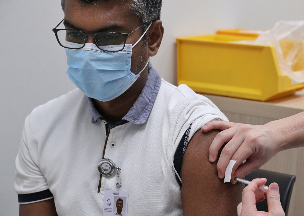 A healthcare worker receives a dose of the coronavirus disease vaccine at the National Centre for Infectious Diseases (NCID) in Singapore December 30, 2020. u00e2u20acu201d Lee Jia Wen/Ministry of Communications and Information handout pic via Reutersnn