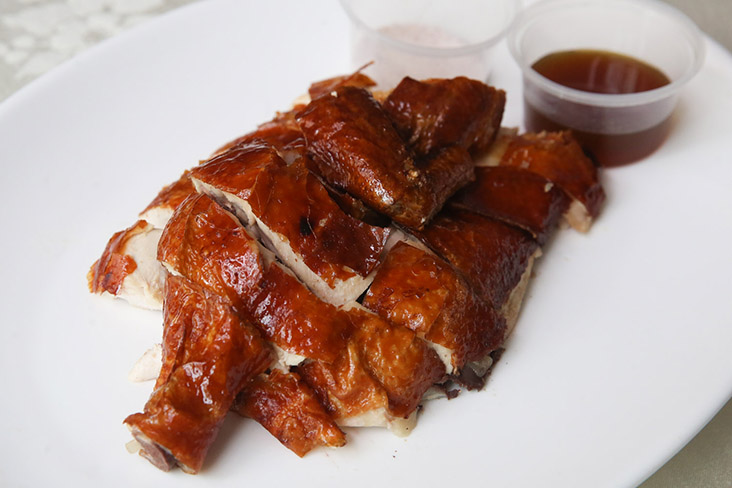 The crispy roast farm chicken has juicy meat that is paired with pepper salt and plum sauce.