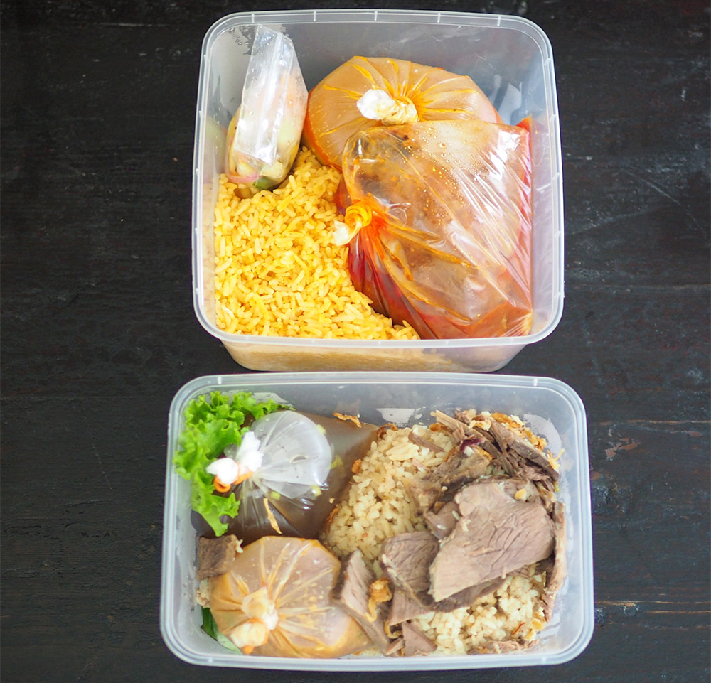 The 'nasi tomato' and 'nasi daging' are neatly packed with the liquid items in separate packets.