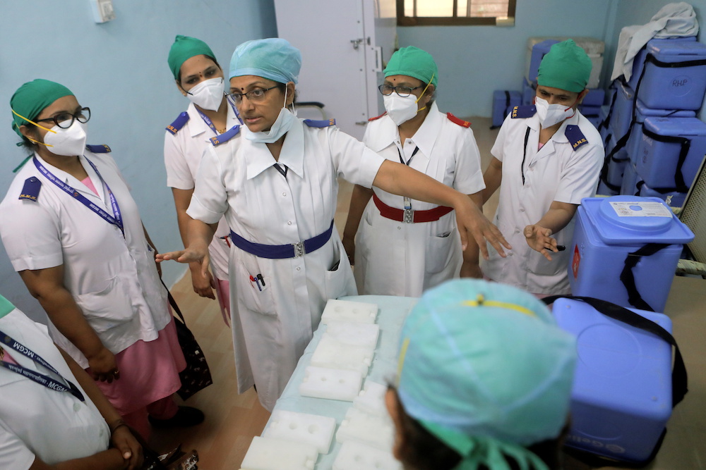 Healthcare workers wait to receive COVISHIELD, a Covd-19 vaccine manufactured by Serum Institute of India, during one of the world's largest Covid-19 vaccination campaigns at Mathalput Community Health Centre in Koraput district of the eastern state of Od