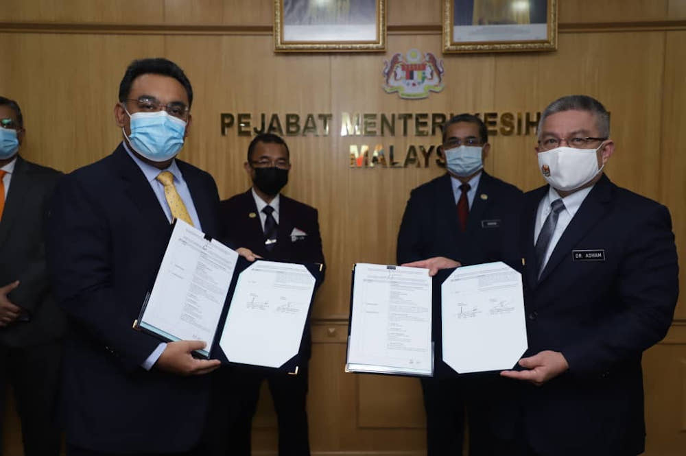 Pharmaniaga group managing director Datuk Zulkarnain Md Eusope and Health Minister Datuk Seri Dr Adham Baba pose after signing the agreement to supply Covid-19 vaccine January 26, 2021.u00e2u20acu201d Picture courtesy of Pharmaniaga