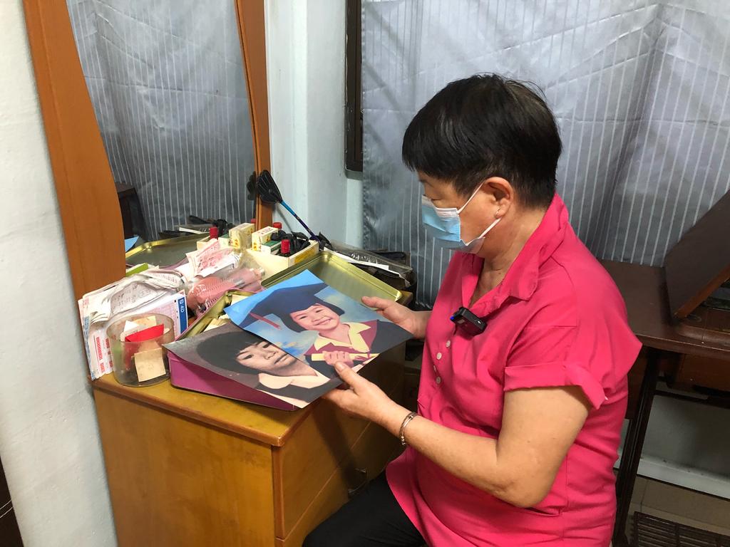 Madam Ang Goon Lay looking at pictures of her daughter Lim Shiow Rong, who went missing and is believed to be murdered in 1995 when she was seven years old. u00e2u20acu2022 TODAY pic