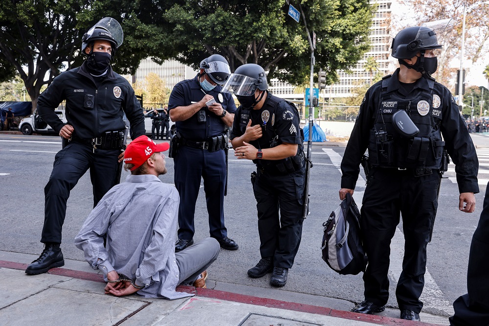 A supporter of US President Donald Trump wearing a Make America Great Again (MAGA) hat looks on upon getting detained by the police while protesting in Los Angeles January 6, 2021. u00e2u20acu2022 Reuters pic 