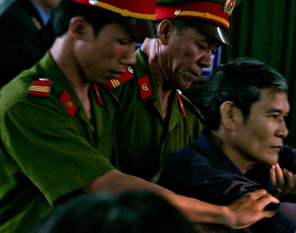 Vietnamese dissident priest Father Thadeus Nguyen Van Ly (right) is escorted by police as he faces a court in Vietnamu00e2u20acu2122s central Hue City March 30, 2007. u00e2u20acu201d Reuters picnn