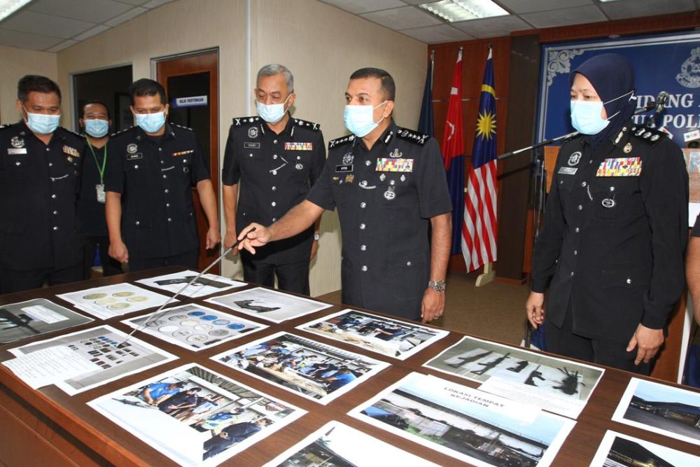 Datuk Ayob Khan Mydin Pitchay points out a picture of the recovered firearms by police from the Sungai Skudai river at the Johor police contingent headquarters in Johor Baru today. u00e2u20acu201d Picture by Ben Tan