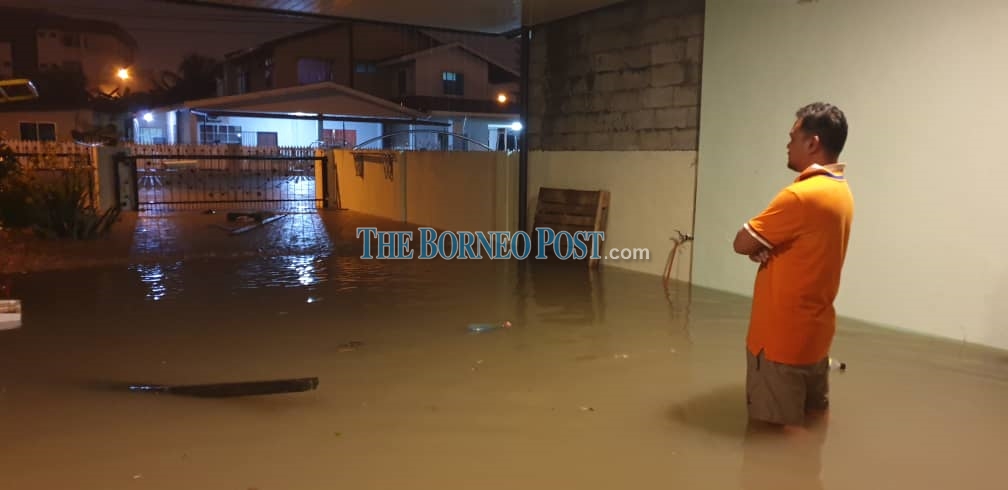 A homeowner stares helplessly as floodwater continues to pour into his neighbourhood. u00e2u20acu2022 Picture by Matthew Umpang via Borneo Post