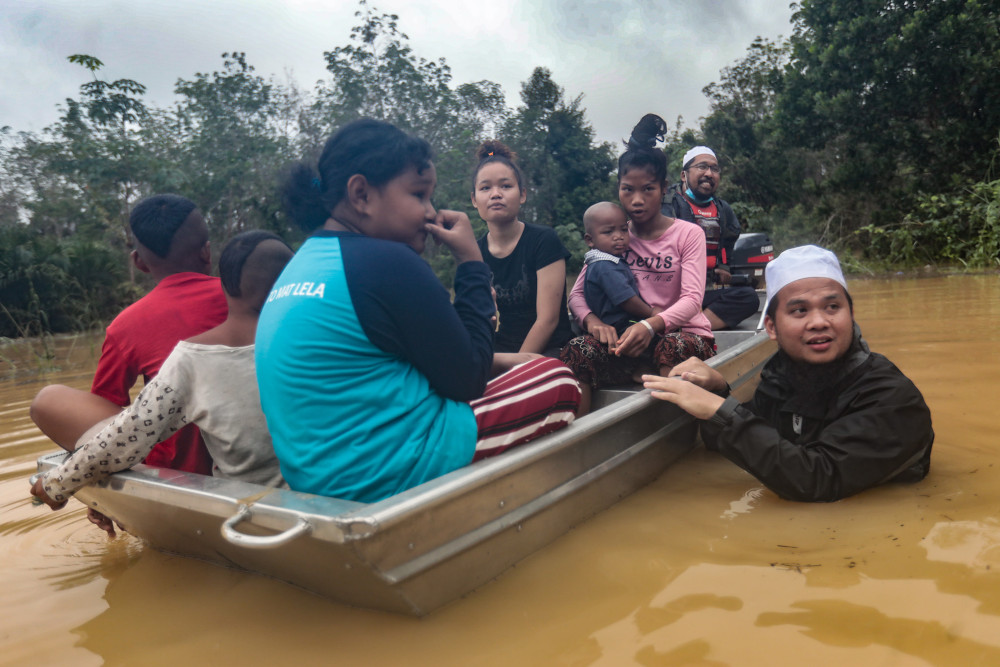 Preacher Ustaz Ebit Lew (in water) sent food to an Orang Asli village in Pekan, Pahang whose supply had been cut off due to flood. u00e2u20acu201d Picture via Facebook/ Ebit Lew
