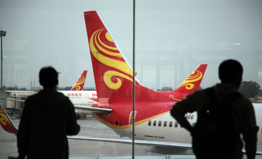 This file photo taken June 12, 2014 shows passengers looking at planes belonging to Chinau00e2u20acu2122s Hainan Airlines at the gate at Haikou airport in Haikou, in southern Chinau00e2u20acu2122s Hainan province. u00e2u20acu201d AFP picnn