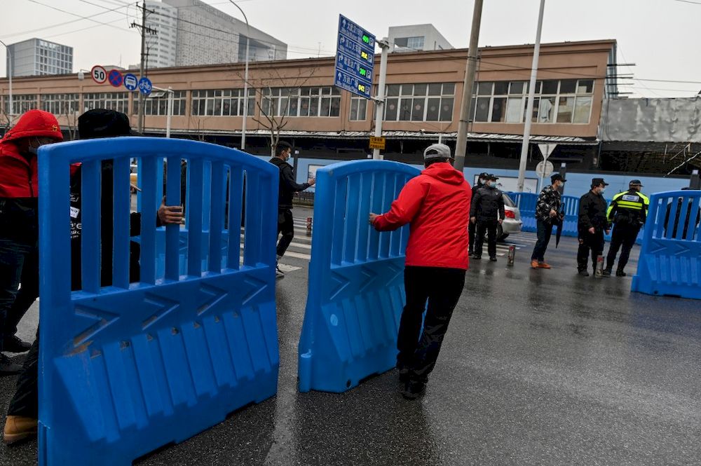 Workers place barriers outside the closed Huanan Seafood wholesale market during a visit by members of the World Health Organization team, investigating the origins of the Covid-19 coronavirus, in Wuhan, China, January 31, 2021. u00e2u20acu201d AFP pic