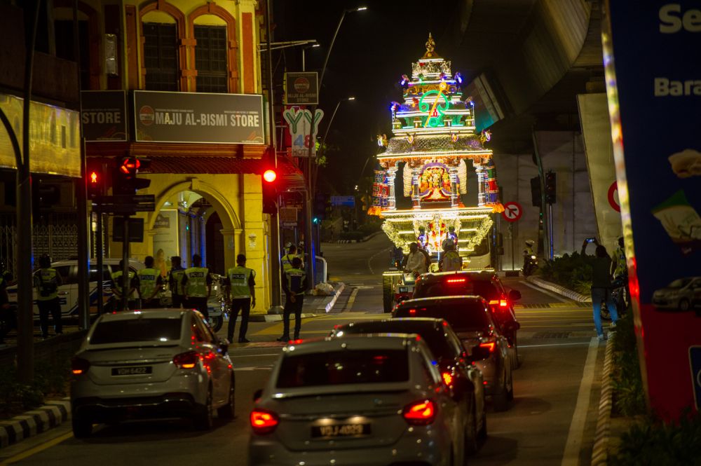 Police escort a chariot bearing the statue of Lord Muruga to the Sri Subramaniam Swamy Temple in Batu Caves January 27, 2021. u00e2u20acu201d Picture by Shafwan Zaidon